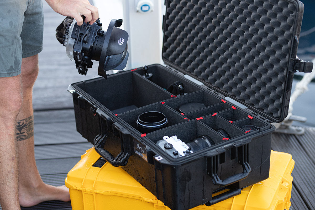 Fotograf med Peli™ case og kameraudstyr i sneen